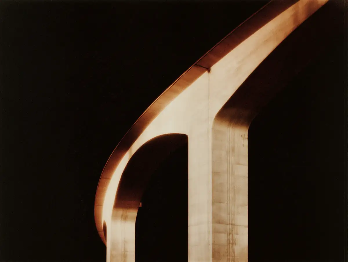 Golden architectural arch against a black field representing ARCO Work & Travel's cross-border passage
